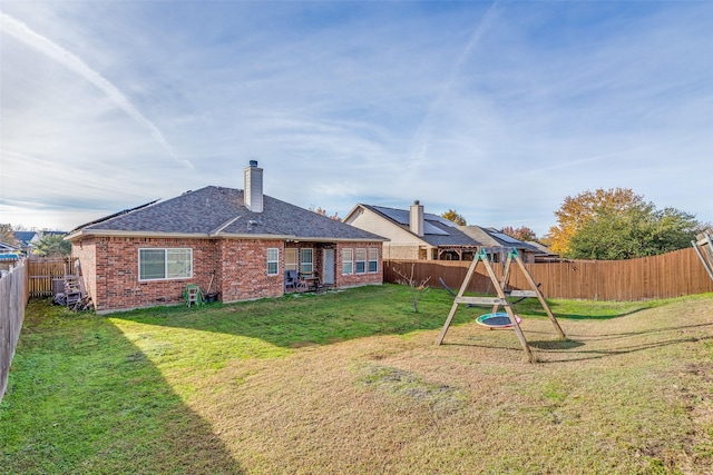 back of property with a playground and a lawn