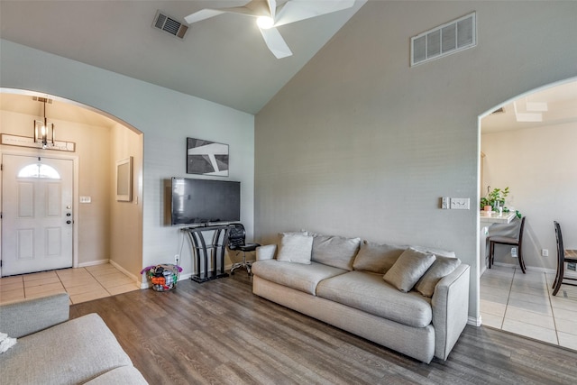 living room featuring wood-type flooring, high vaulted ceiling, and ceiling fan