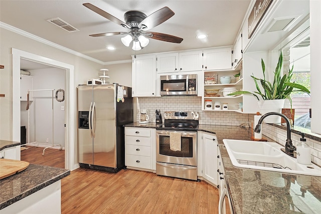 kitchen with appliances with stainless steel finishes, light wood-type flooring, ceiling fan, sink, and white cabinetry