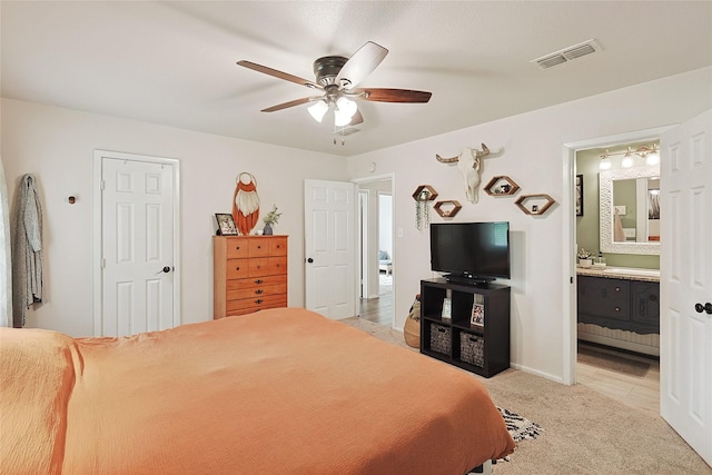 carpeted bedroom with ceiling fan and ensuite bathroom