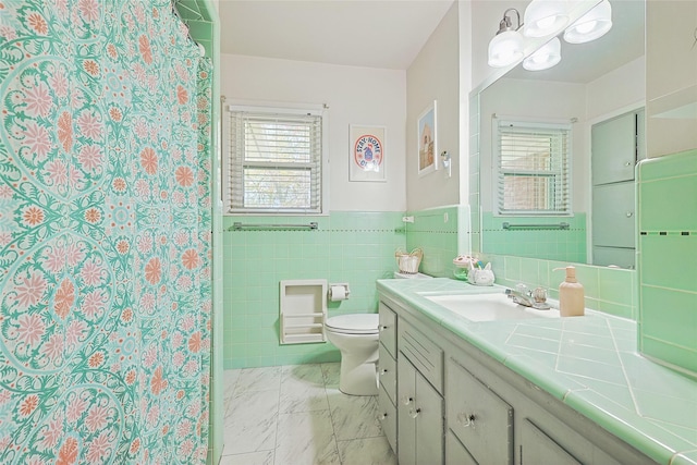 bathroom featuring curtained shower, vanity, tile walls, and toilet