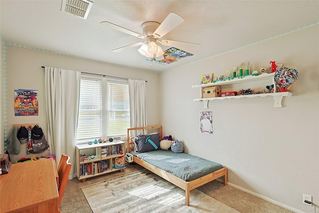 bedroom featuring carpet flooring, ceiling fan, and a textured ceiling