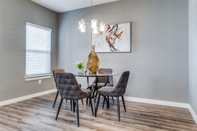 dining space featuring hardwood / wood-style floors and a notable chandelier