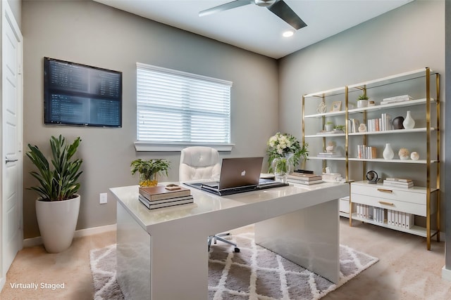 carpeted home office featuring ceiling fan