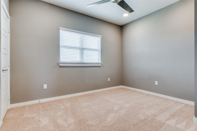 empty room featuring light colored carpet and ceiling fan