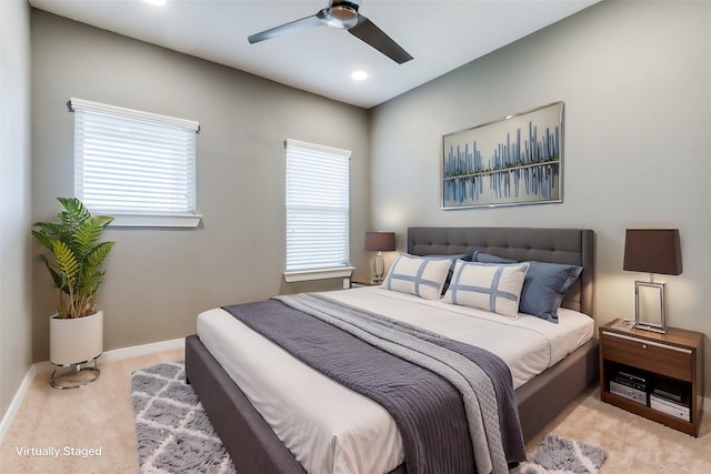 carpeted bedroom featuring multiple windows and ceiling fan