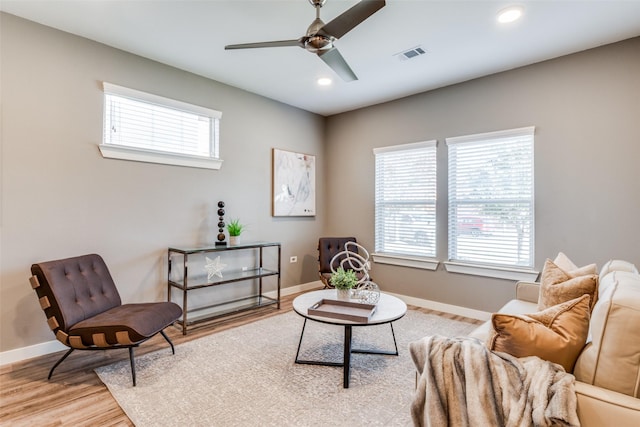 living area with ceiling fan and light hardwood / wood-style floors