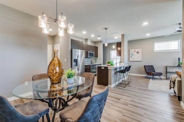 dining area featuring light wood-type flooring and ceiling fan