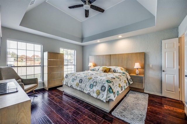 bedroom featuring a tray ceiling, ceiling fan, and dark hardwood / wood-style floors