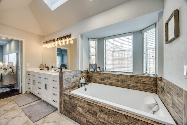 bathroom with vanity, tile patterned floors, lofted ceiling, and tiled tub