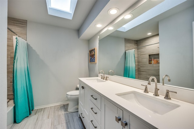 full bathroom featuring shower / bath combo, vanity, a skylight, and toilet