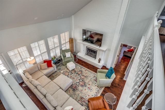 living room with hardwood / wood-style floors and high vaulted ceiling