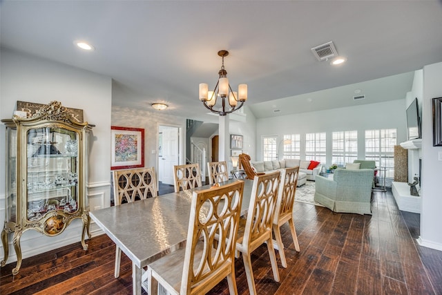 dining space featuring dark hardwood / wood-style flooring, vaulted ceiling, and a notable chandelier