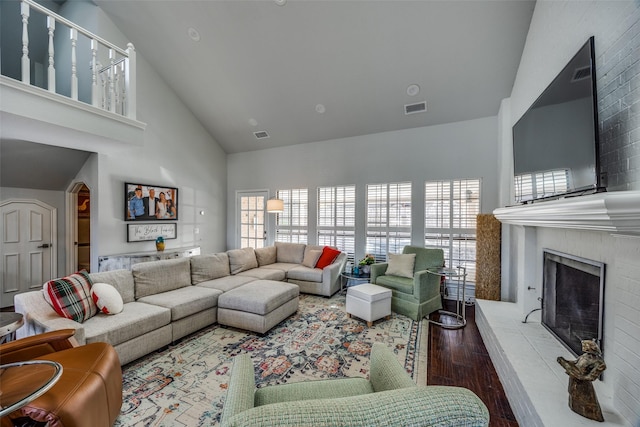 living room with hardwood / wood-style flooring, high vaulted ceiling, and plenty of natural light