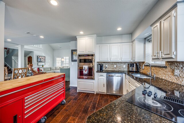 kitchen with decorative backsplash, sink, white cabinets, and appliances with stainless steel finishes