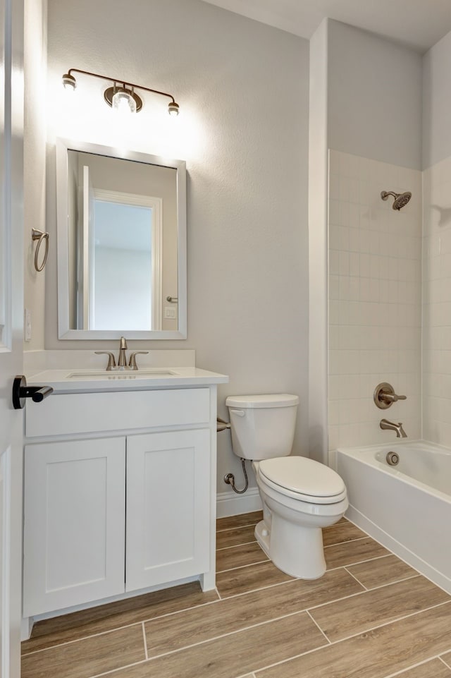 full bathroom featuring vanity, hardwood / wood-style flooring, toilet, and tiled shower / bath