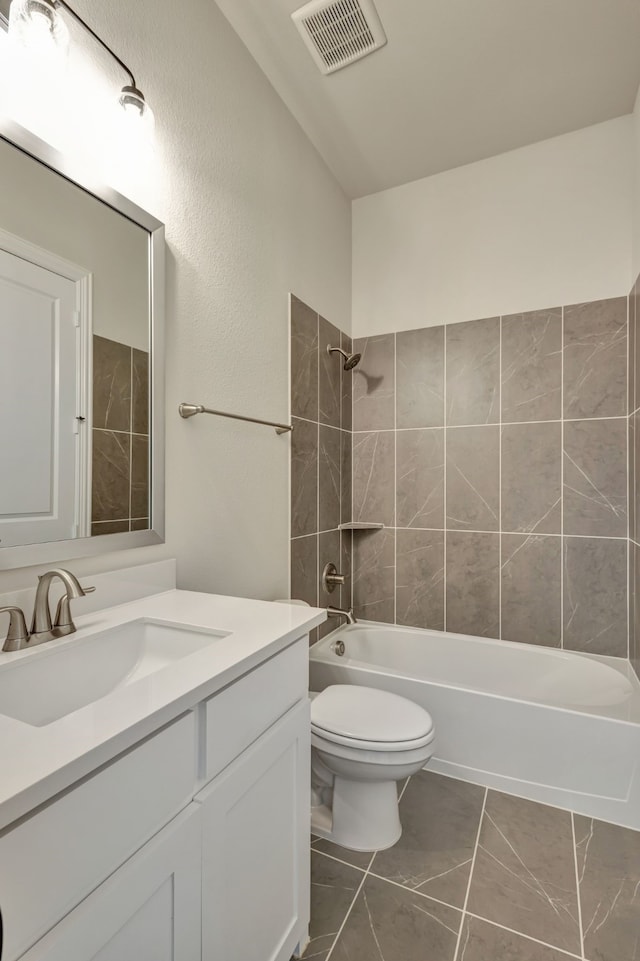 full bathroom featuring tile patterned flooring, vanity, toilet, and tiled shower / bath