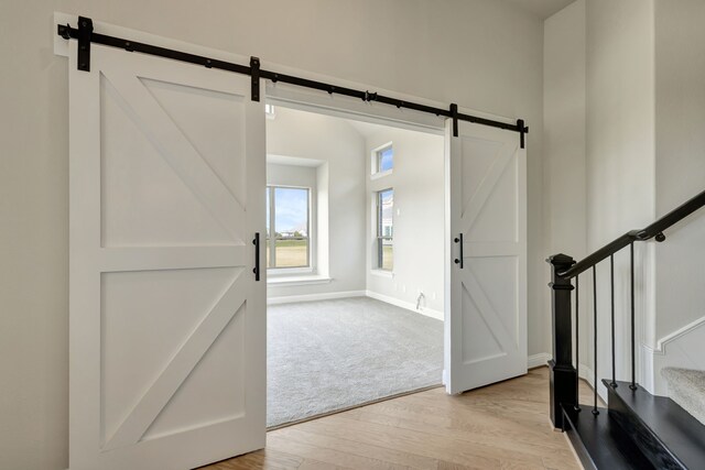 entryway featuring a barn door and light hardwood / wood-style flooring