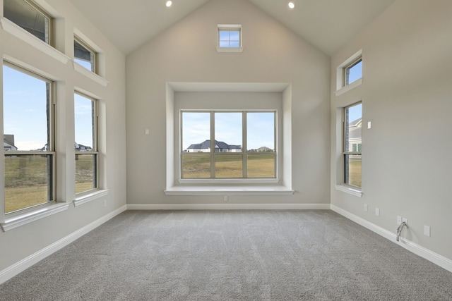 empty room with light carpet and high vaulted ceiling