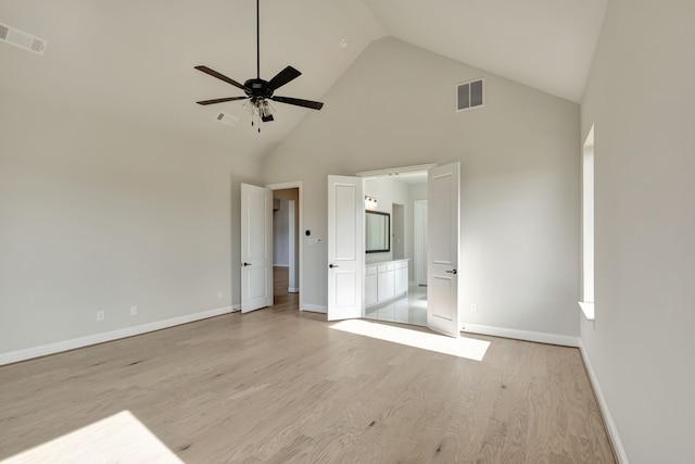 unfurnished bedroom with ceiling fan, high vaulted ceiling, ensuite bathroom, and light hardwood / wood-style floors