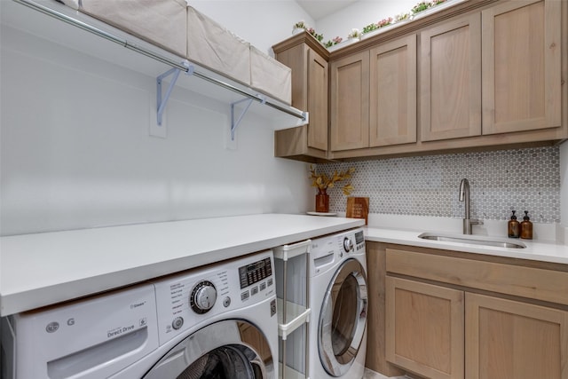 laundry room with cabinets, washer and clothes dryer, and sink