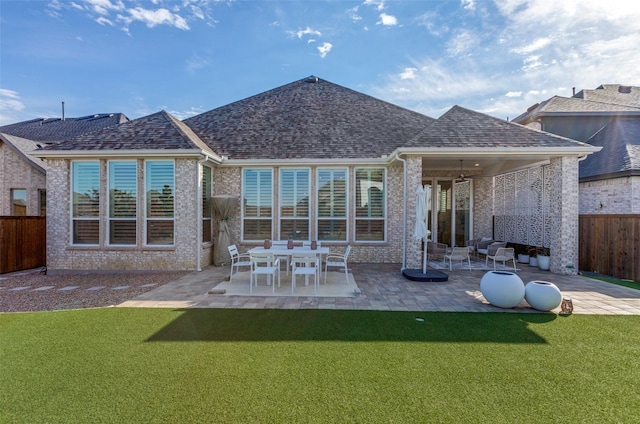 rear view of property featuring ceiling fan, a patio area, and a yard