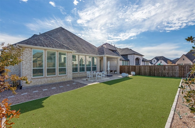 back of house featuring a lawn and a patio area