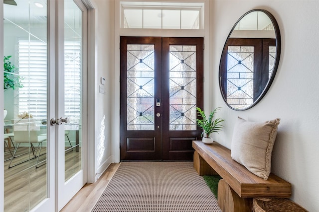 foyer with plenty of natural light, light hardwood / wood-style flooring, and french doors