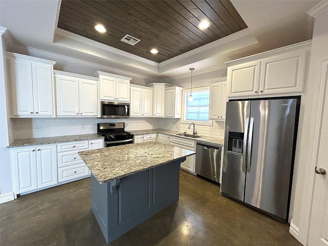 kitchen with stainless steel appliances, light stone counters, white cabinets, decorative light fixtures, and a raised ceiling