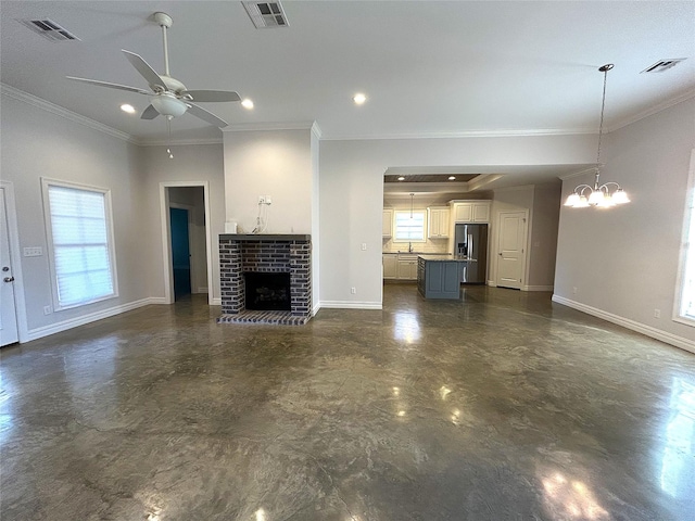 unfurnished living room with ornamental molding, a brick fireplace, and ceiling fan with notable chandelier