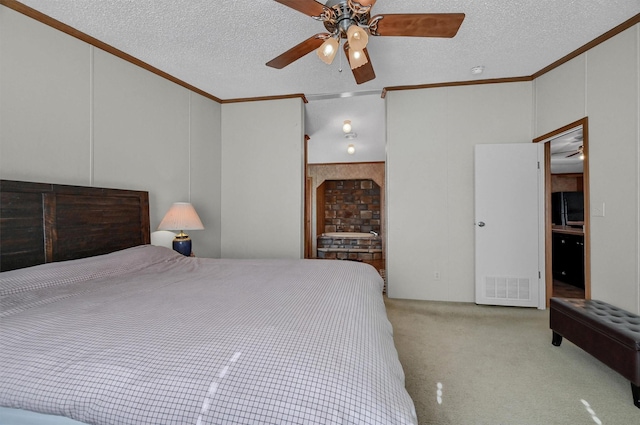 carpeted bedroom featuring ceiling fan, crown molding, a textured ceiling, and ensuite bath