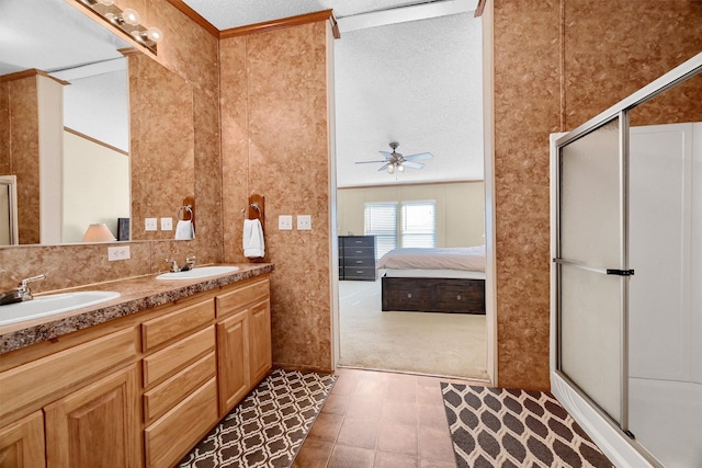 bathroom with ceiling fan, a shower with door, vanity, and a textured ceiling