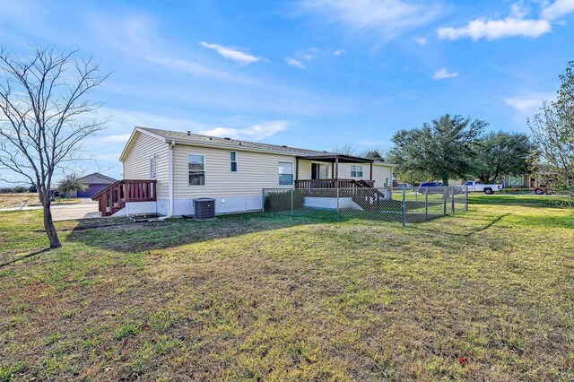 rear view of property featuring a lawn and central AC