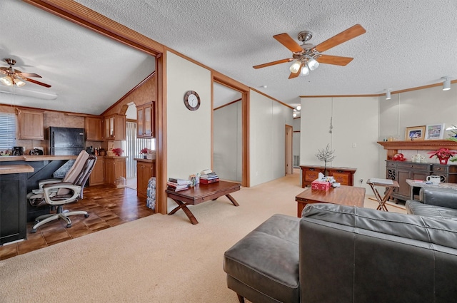 living room featuring vaulted ceiling, a healthy amount of sunlight, a textured ceiling, and ornamental molding