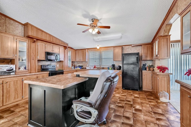 kitchen with a center island, vaulted ceiling, a textured ceiling, black appliances, and ornamental molding