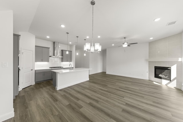 216 Hope Orchards, Lavon, TX 75166 - kitchen with wall chimney range hood, gray cabinetry, a sink, ceiling fan, and a tile fireplace
