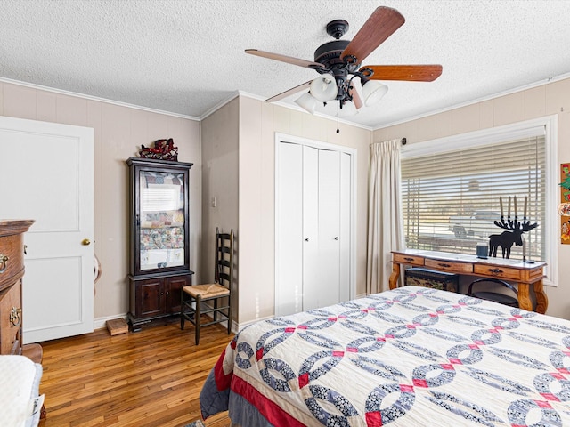 bedroom with crown molding, a closet, a textured ceiling, and hardwood / wood-style flooring