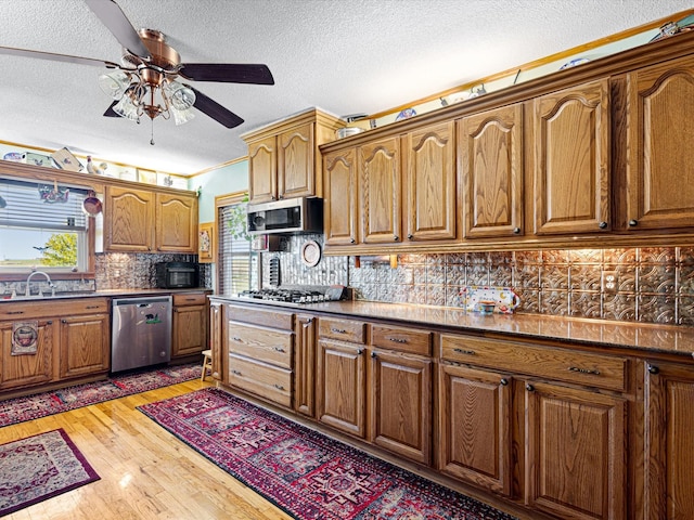 kitchen with sink, backsplash, stainless steel appliances, dark hardwood / wood-style floors, and a textured ceiling