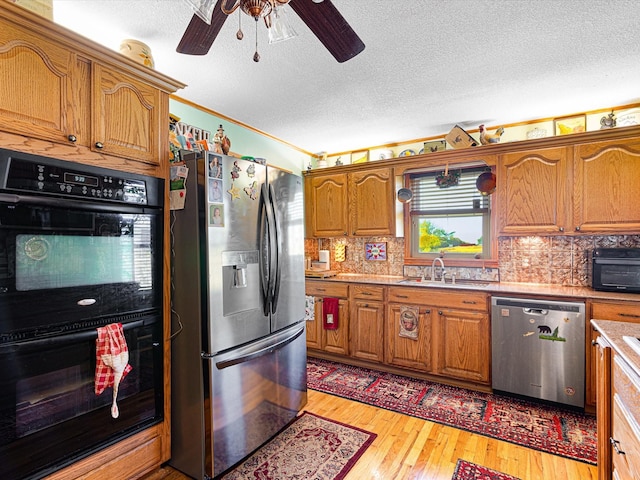 kitchen with sink, backsplash, stainless steel appliances, and light hardwood / wood-style floors