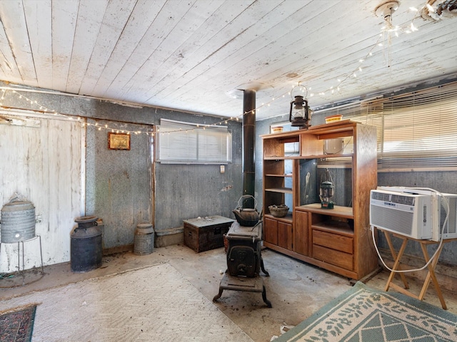 basement with a wood stove, cooling unit, and wooden ceiling