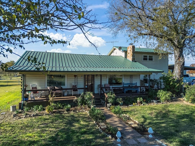 rear view of house with a porch and a yard