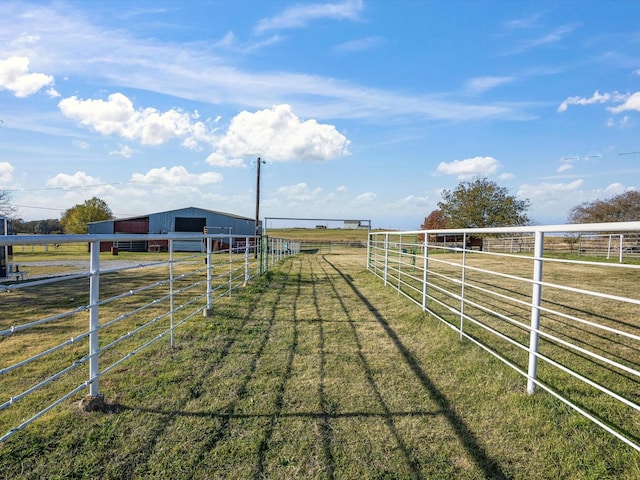 view of yard with a rural view and an outdoor structure