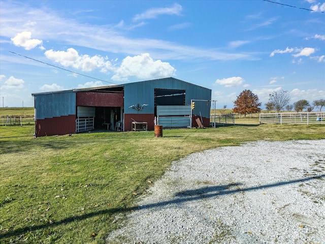 view of outbuilding featuring a rural view and a lawn