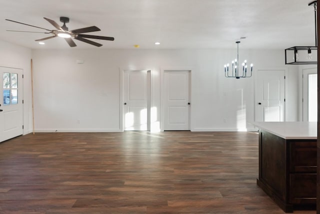 entrance foyer with ceiling fan with notable chandelier and dark hardwood / wood-style flooring