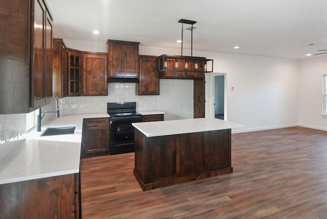 kitchen with dark hardwood / wood-style flooring, sink, decorative light fixtures, a center island, and black electric range oven