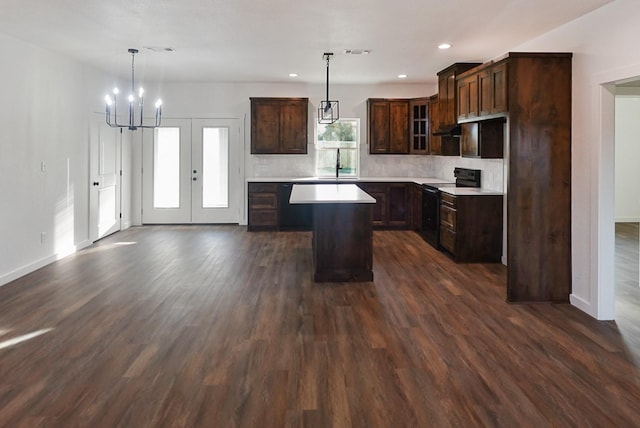 kitchen featuring black / electric stove, dark brown cabinets, a center island, and decorative light fixtures