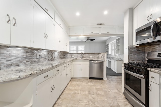 kitchen featuring white cabinets, sink, ceiling fan, tasteful backsplash, and stainless steel appliances