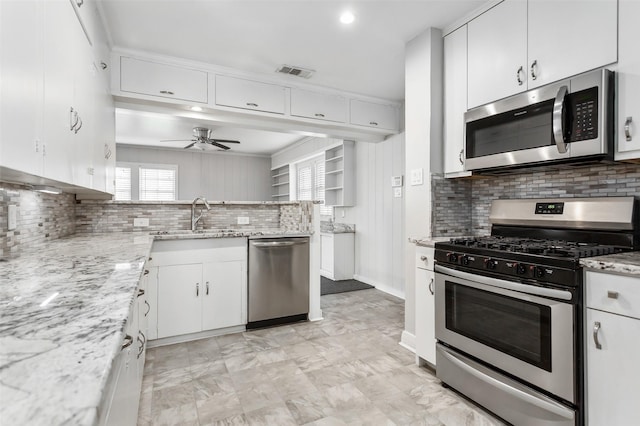 kitchen featuring white cabinetry, sink, ceiling fan, stainless steel appliances, and decorative backsplash