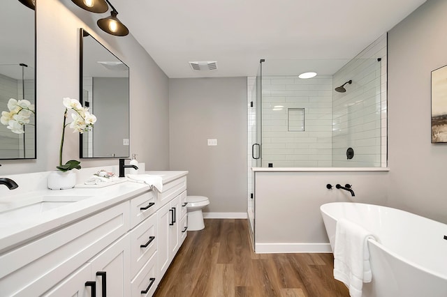 full bathroom featuring hardwood / wood-style floors, vanity, toilet, and independent shower and bath