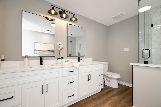 bathroom with vanity, hardwood / wood-style flooring, toilet, and a shower with shower door